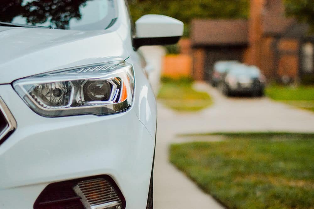 Close up of white car with another driveway in background