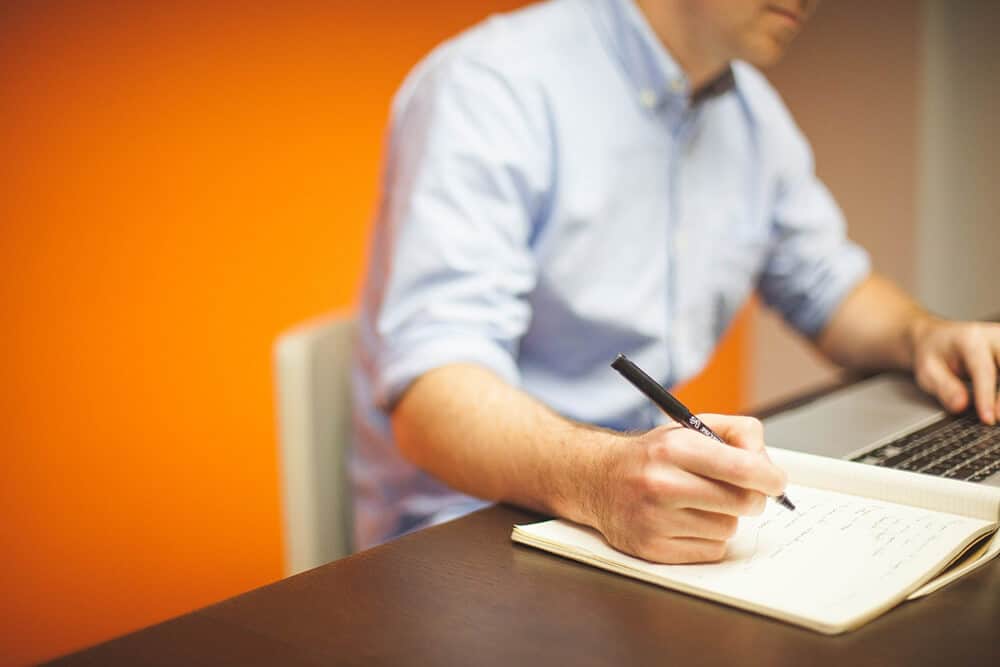 person on laptop taking notes